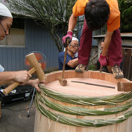 Craftspeople hit bamboo hoops with hammers to tighten a barell.
